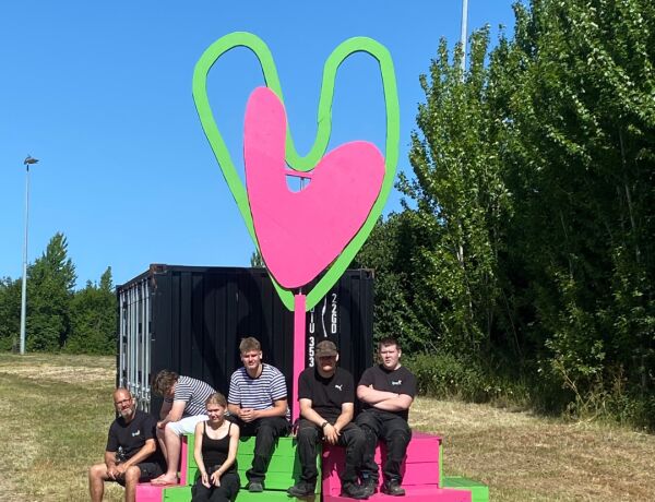 Elever og underviser sidder på det færdige Vighjerte ved Vig Festival.