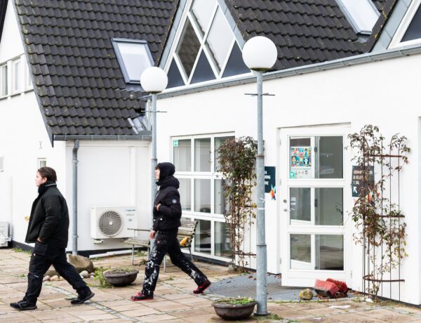 To personer går foran FGU-skolens hvide bygning i Svebølle med store tagvinduer og mørkt tegltag.