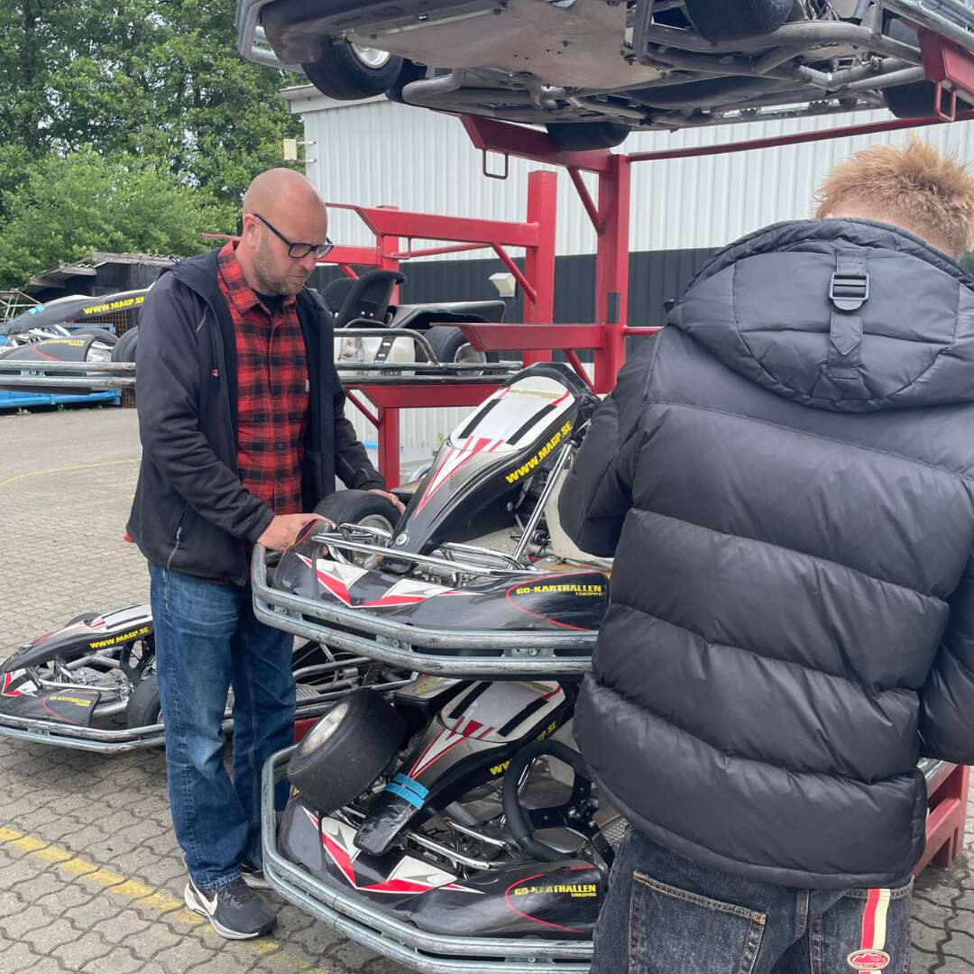 En medarbejder viser en gokart frem og fortæller om dens opbygning til eleverne.