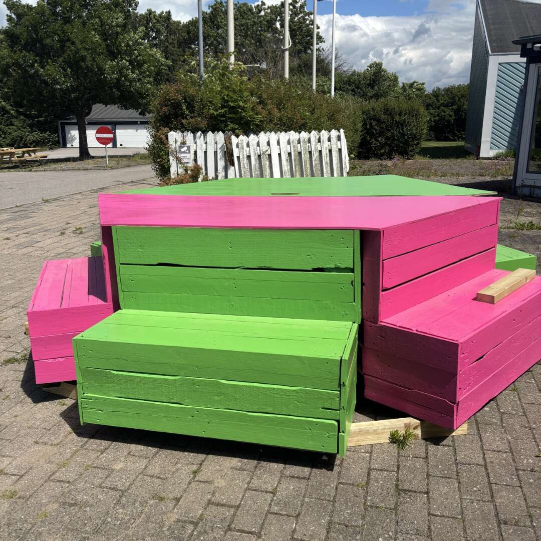 Vighjerte med grønne og pink siddepladser og bord.