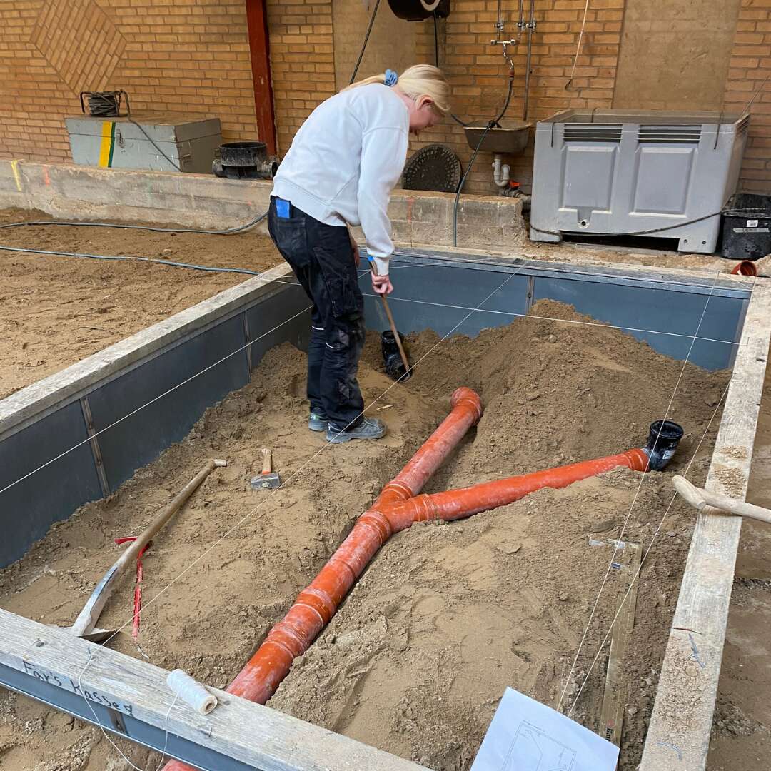 Elev arbejder med kloakrør og jordarbejde på NEG Audebo
