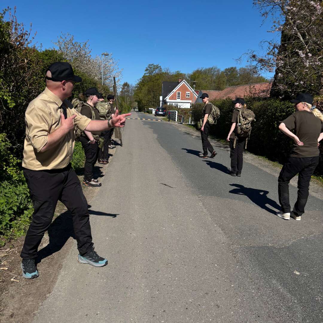 Underviser instruerer elever under øvelse på vej udendørs