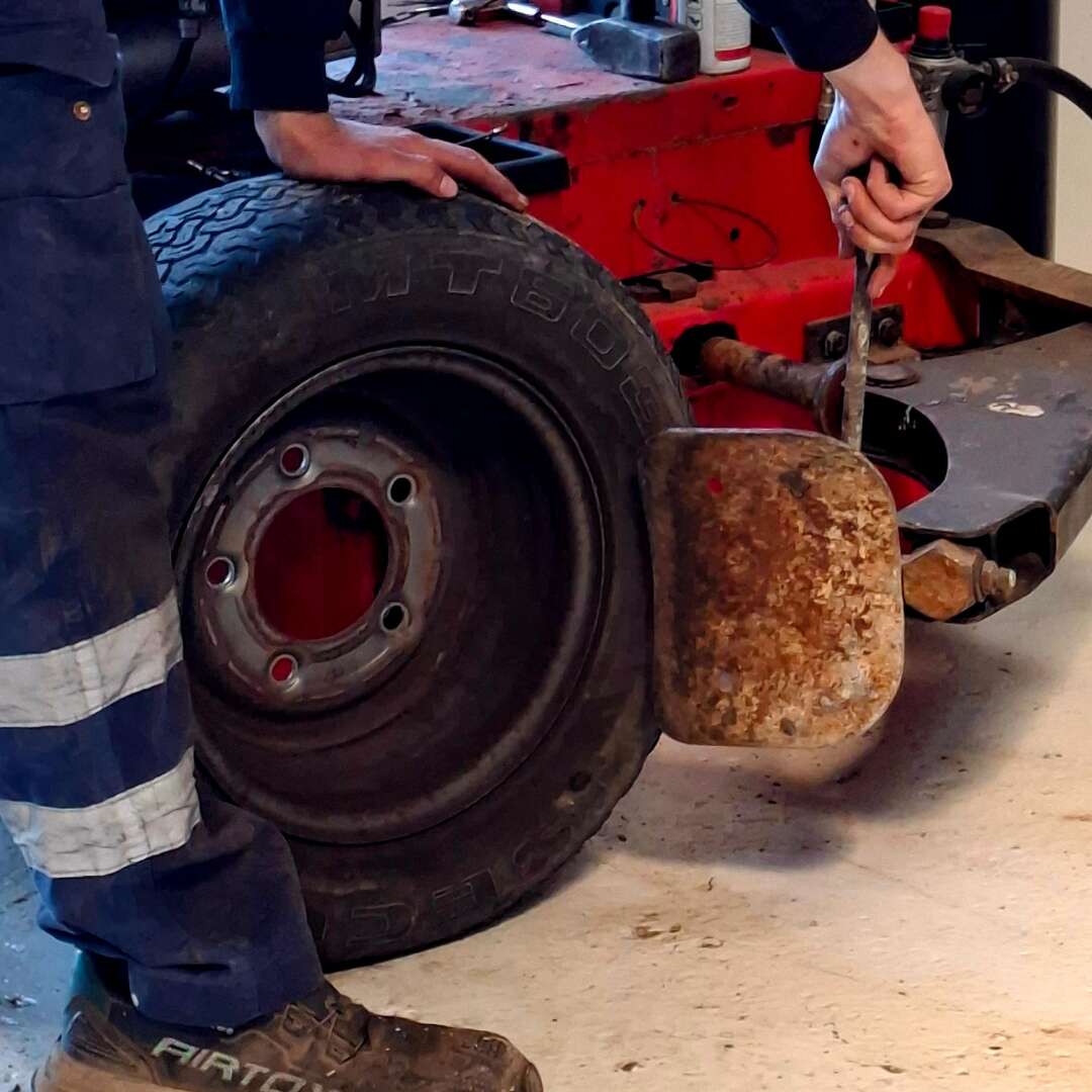 Bjarke arbejder med dækskifte på værkstedet.