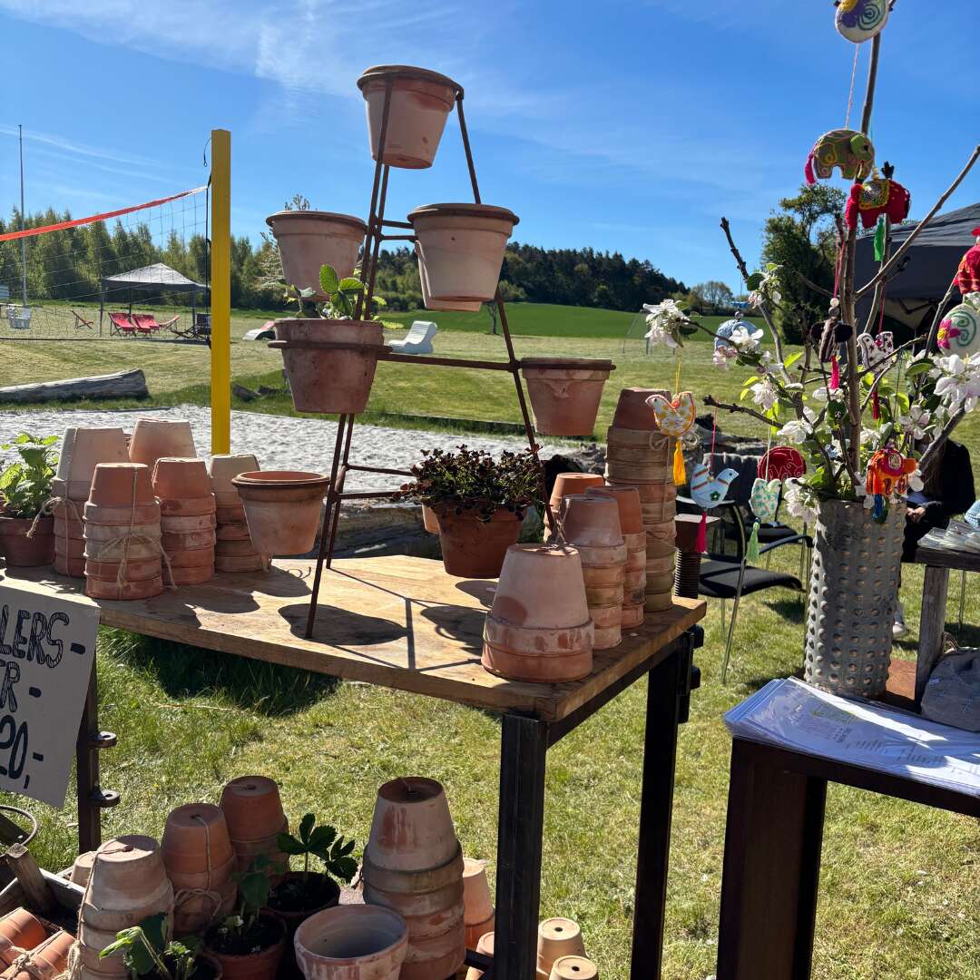 Håndlavede lerpotter og pynt til salg på loppemarked i solen.
