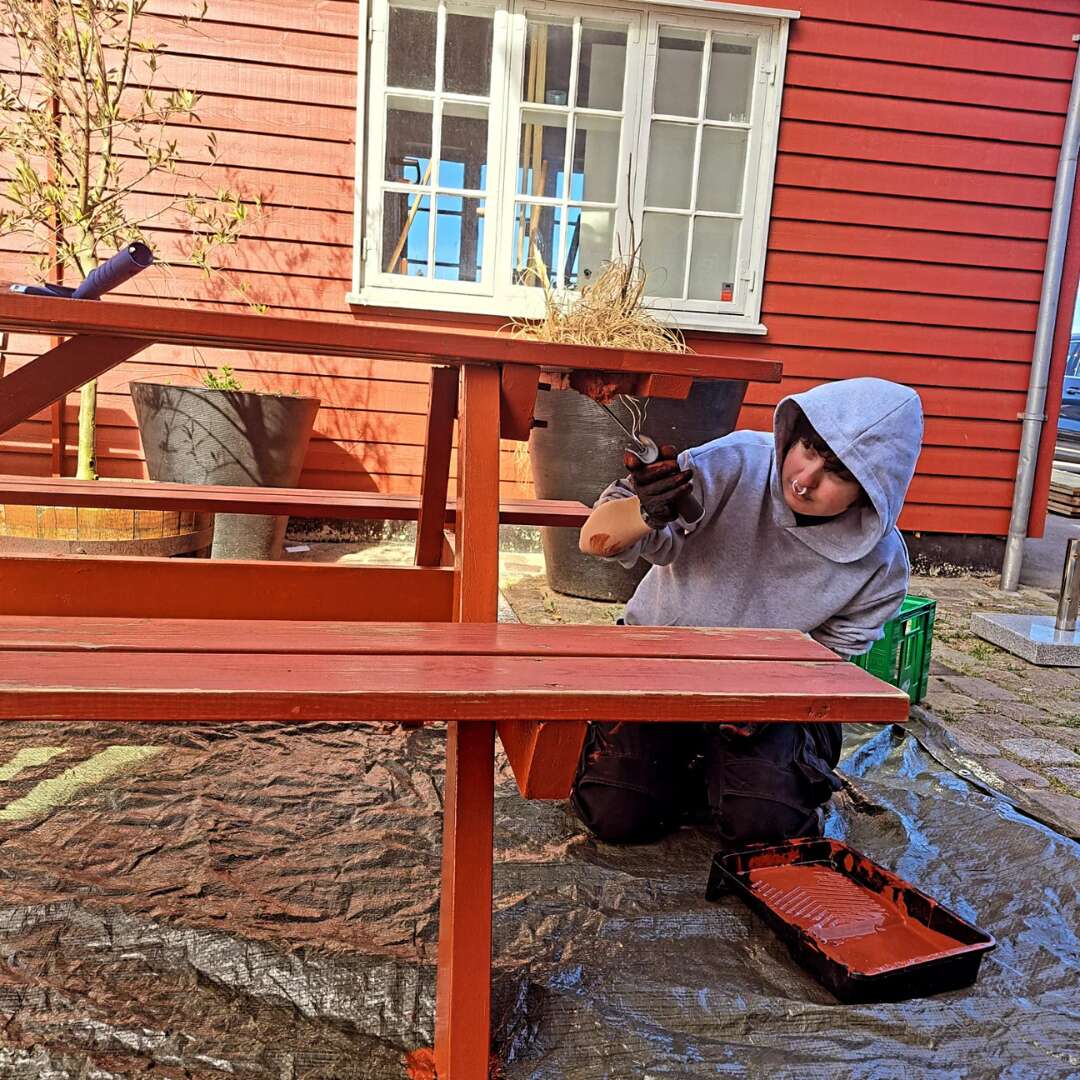 Elev maler bord-bænke-sæt som en del af forberedelserne til Skvulp Festival.
