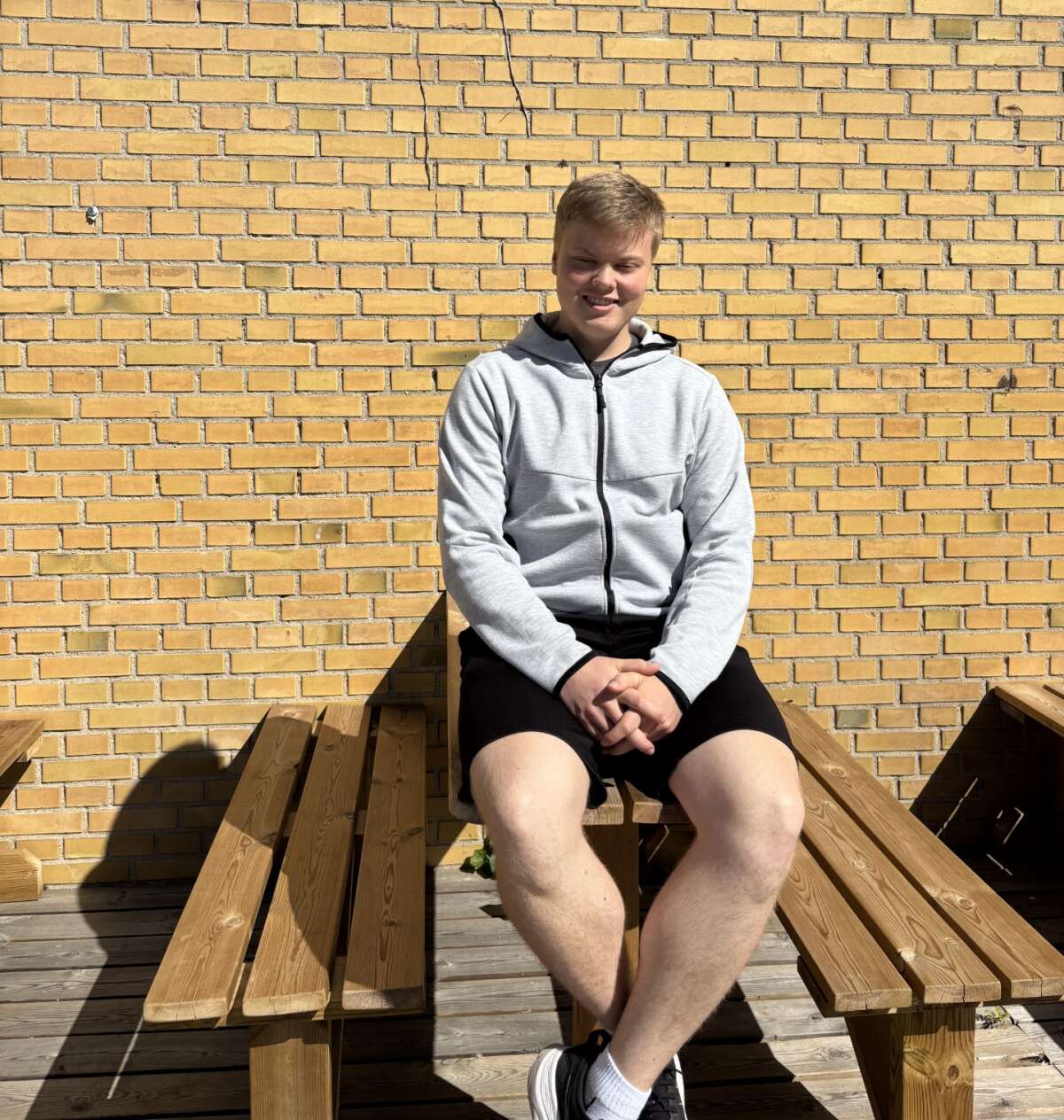 Tobias Bastholm sidder på en bænk uden for FGU Nordvestsjælland i Holbæk.