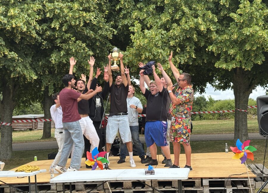 Elever jubler på en scene og løfter en pokal efter sejr ved FGU Festival 2026.